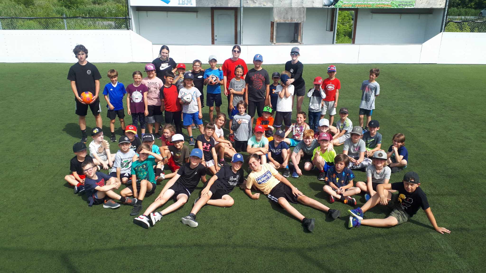 Des campeurs et leurs moniteurs réunis sur un terrain de soccer