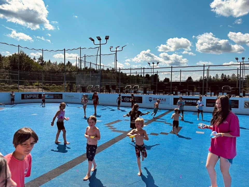 Des campeurs et une animatrice pendant des jeux sur une surface extérieure